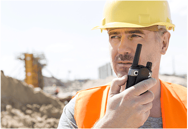 Construction worker using a radio for communications